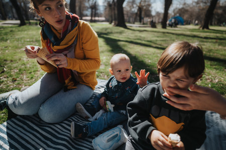 Family having a picnic outdoors, enjoying treats while bonding in a park setting