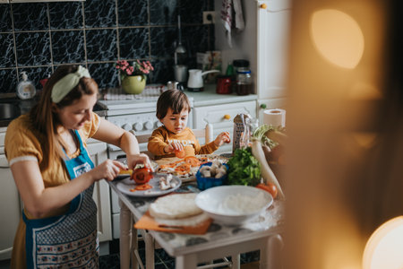 A mother and her child cooking together in a cozy home kitchen atmosphere.の写真素材