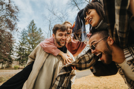 Group of friends enjoying playful moments in an autumn park