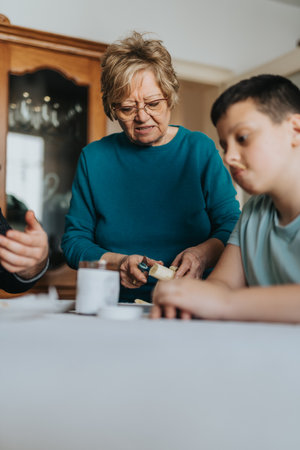 Senior woman preparing food at a table with children engaged nearby