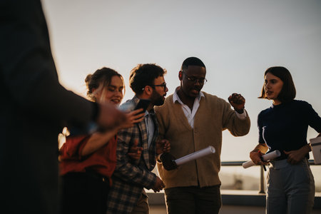Diverse business colleagues celebrate together on rooftop at sunset