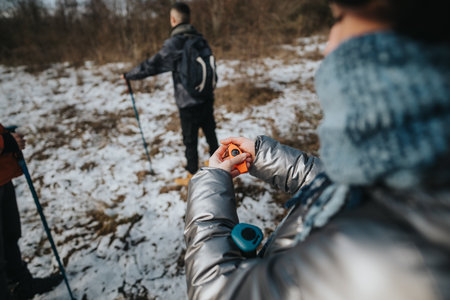 Group of hikers exploring a snowy trail with a compass for navigation.の写真素材