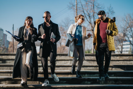 Young professionals walking together outdoors while engaged in a discussionの写真素材