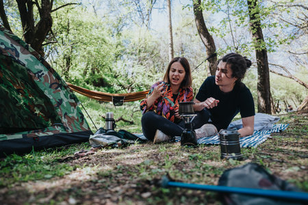 Young couple enjoying a hiking trip, facing challenges while camping in a forested areaの写真素材