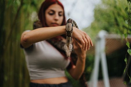 Girl holding a snake in an outdoor natural settingの写真素材