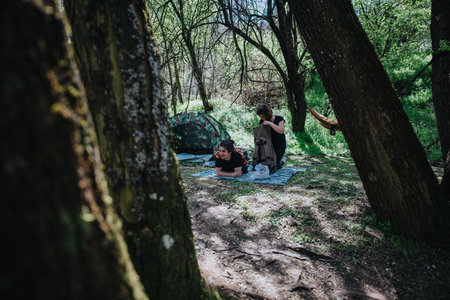 Young couple enjoying a relaxing camping experience in a scenic forest during springtimeの写真素材