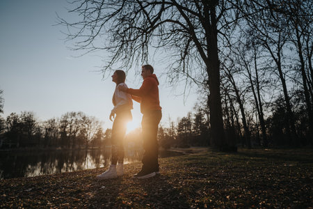 Couple enjoying a peaceful sunset stroll in a serene park environmentの写真素材