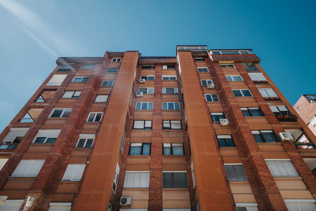Facade of a modern building with red bricks and large windows under sunlight