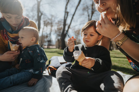 Family enjoying ice cream together outdoors in a park settingの写真素材