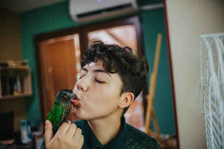 Young man shares a tender moment with his pet parrot