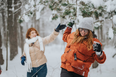 Two friends enjoying playful winter activities in a snowy forestの写真素材
