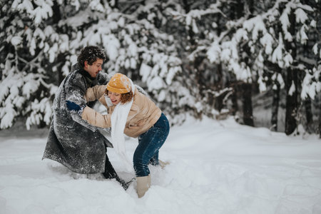 Friends Engaging in a Playful Snowball Fight in a Scenic Winter Forestの写真素材