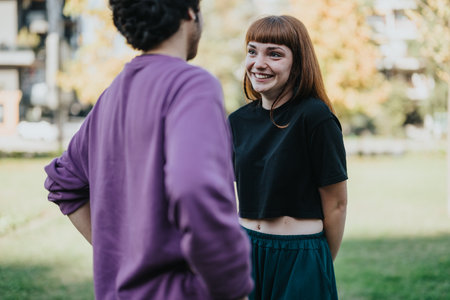 Young couple enjoying a conversation outdoors in autumn parkの写真素材