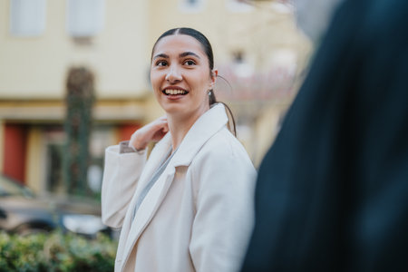 Smiling professional businesswoman interacting during an outdoor city walkの写真素材
