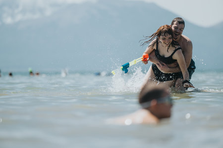 Couple Having Fun in the Water with a Toy on a Summer Dayの写真素材