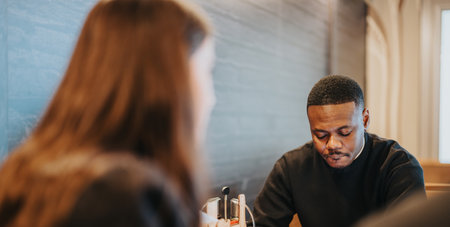 Two business professionals in casual discussion over a table in a meetingの写真素材