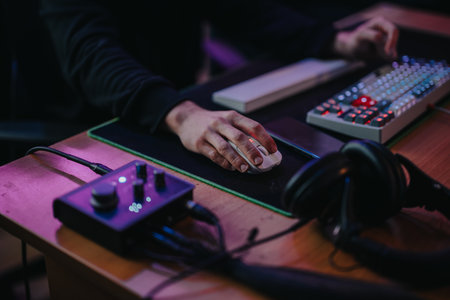 Focused gaming setup with illuminated keyboard and audio controls in action