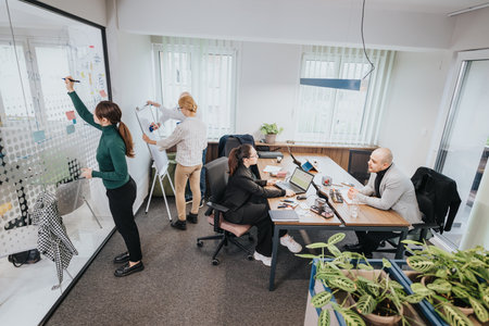 Team discussing ideas and working productively inside a modern office space with a collaborative...