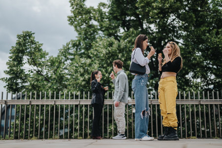 Friends enjoying ice cream while having a conversation outdoors on a sunny day