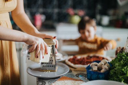 Woman Preparing Food with Child in Kitchen Setting, Creating Homemade Mealsの写真素材