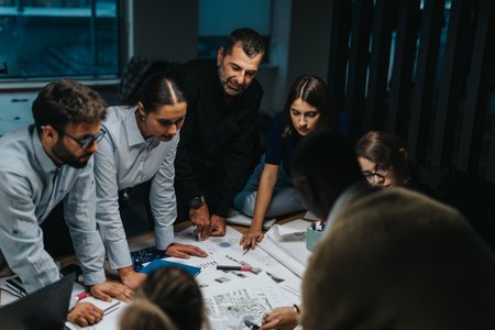 A diverse group of business people brainstorm ideas around a table, showcasing teamwork and innovative thinking in a modern workplace setting.の写真素材
