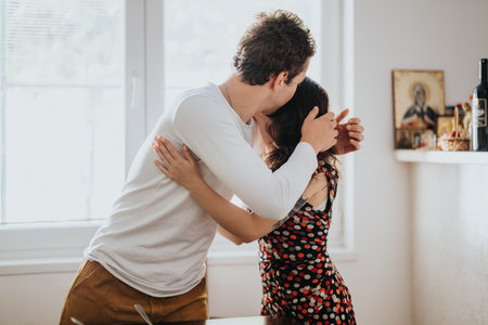 Warm embrace between young couple in cozy home settingの写真素材