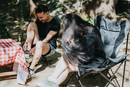 Friends enjoying a casual outdoor day seated and sharing light moments togetherの写真素材
