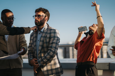 Diverse business colleagues celebrating on high tower balcony at sunsetの写真素材