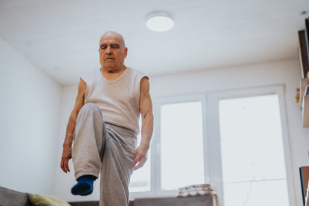 Senior gentleman exercising indoors focusing on flexibility and balanceの写真素材