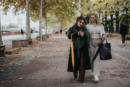 Two Women Walking Together on an Autumn Day in the Parkの写真素材