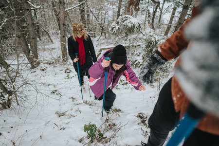 Group of friends enjoying a snowy day hike in a forestの写真素材