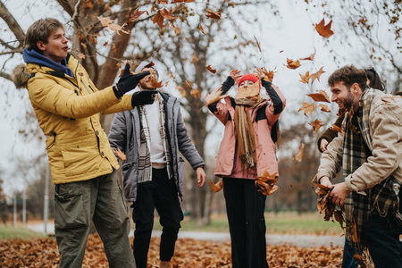 Group of friends enjoying autumn leaves in a parkの写真素材
