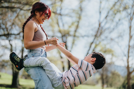 Mother and child playing joyfully together in a sunny outdoor parkの写真素材