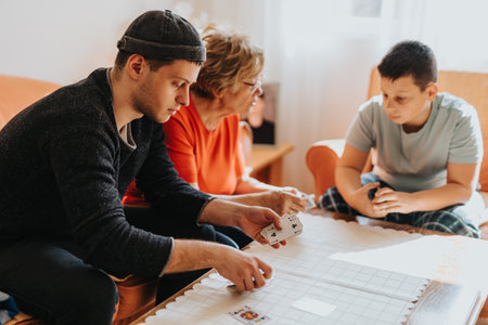Three People Enjoy Quality Time Playing a Interactive Table Game Togetherの写真素材
