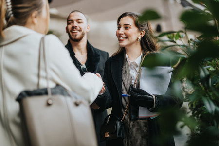Young professionals engaging in a positive and friendly business networking handshakeの写真素材