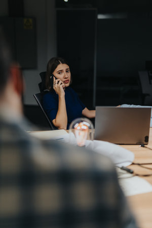 Businesswoman working late at night in an office on her smart phone