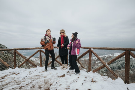 Group of friends enjoying a snowy winter day on a mountain viewpoint
