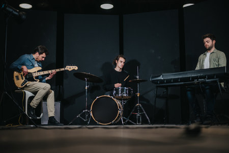 Three musicians performing in a dimly lit studio settingの写真素材