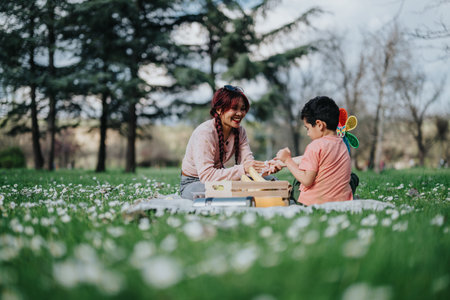 Mother and son having a picnic on a sunny day in springtime park