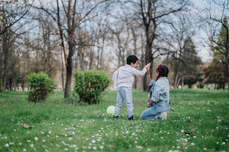 Mother and child enjoying a playful moment in a green parkの写真素材