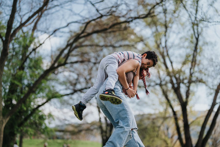 Mother and son playing together outdoors in a lush green parkの写真素材