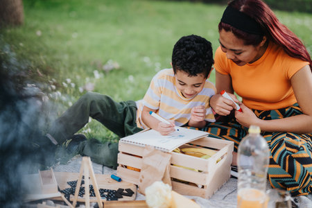 Mother and son creativity and fun together during an outdoor picnic dayの写真素材