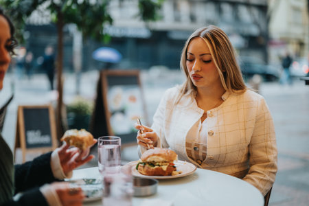 Young woman enjoying a meal at an outdoor urban cafe on a cloudy dayの写真素材