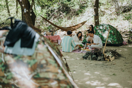 Friends enjoying a leisurely picnic during a camping trip in the forestの写真素材