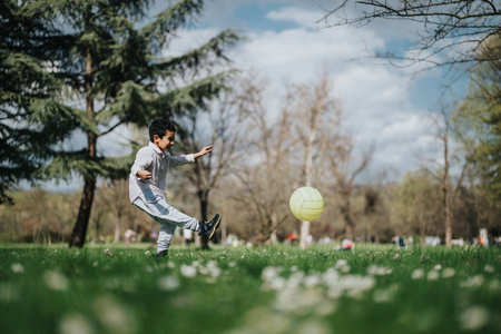 Young boy playing with a ball in a beautiful natural parkの写真素材