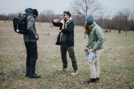 Friends discussing outdoors in a natural setting during a casual hikeの写真素材
