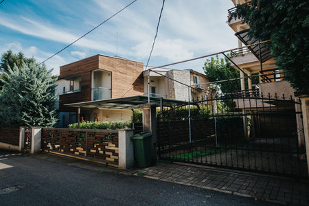 Modern residential home with gated yard on a sunny dayの写真素材