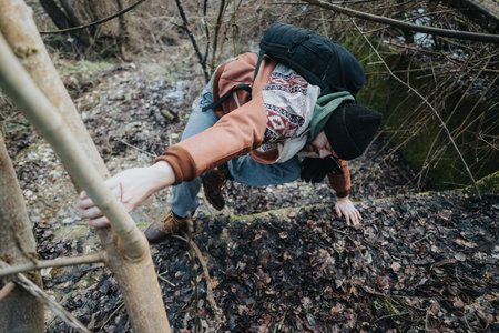 Young individual hiking in a forested area during a cool winter dayの写真素材