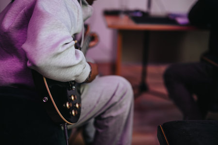 Musician playing electric guitar in a cozy indoor settingの写真素材