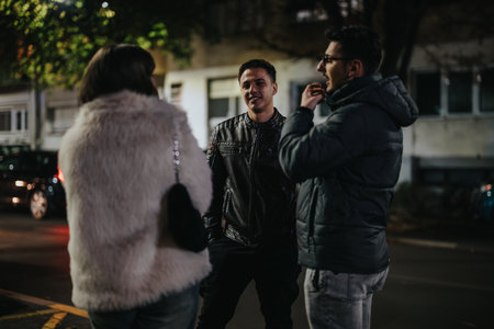 Group of friends having a conversation during nighttime outdoorsの写真素材